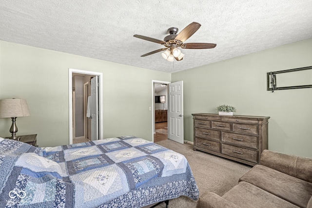 bedroom with a ceiling fan, light carpet, and a textured ceiling