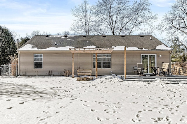 snow covered property with a fire pit and fence