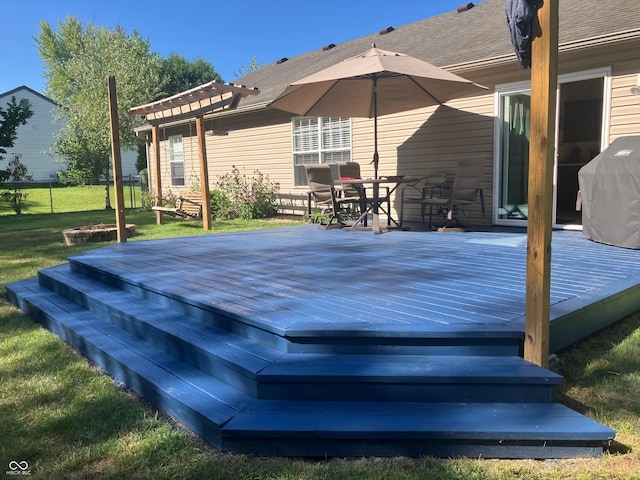 wooden deck featuring grilling area, outdoor dining area, and a yard