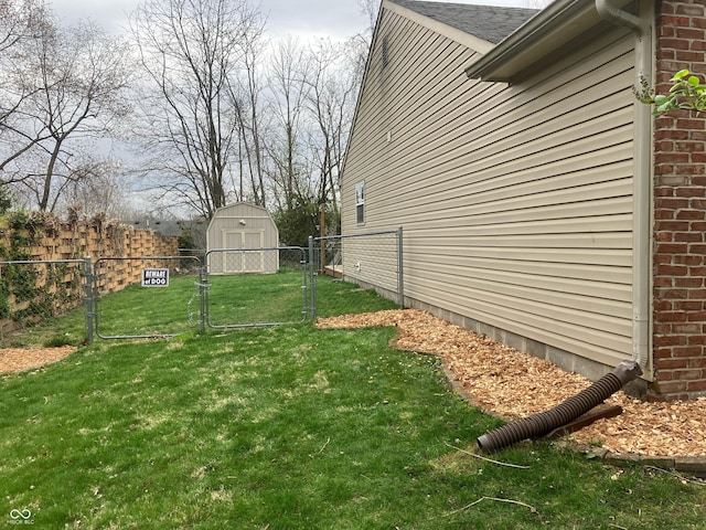 view of yard featuring a gate, fence, an outdoor structure, and a shed