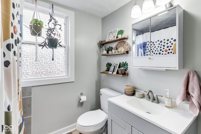 bathroom with toilet, curtained shower, and vanity