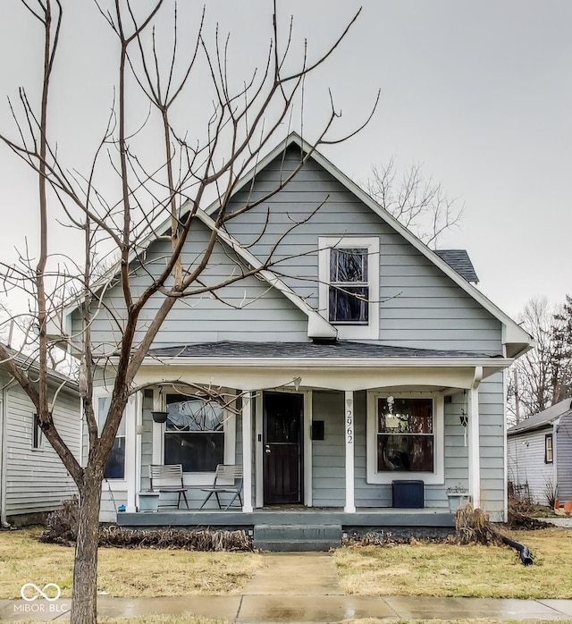 bungalow-style house featuring a porch and roof with shingles