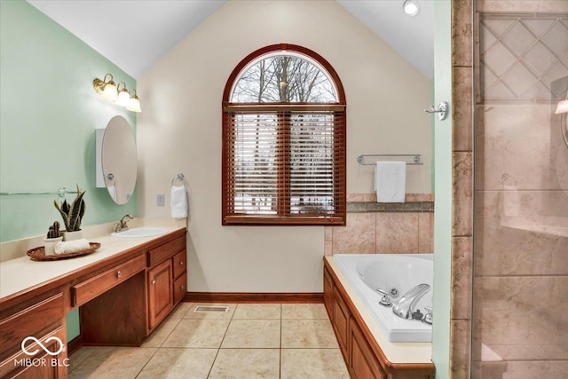 bathroom with a bathing tub, vanity, tile patterned floors, and lofted ceiling