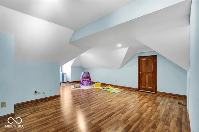 bonus room with hardwood / wood-style flooring and vaulted ceiling