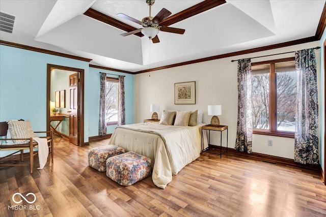 bedroom with a tray ceiling, ceiling fan, crown molding, and wood-type flooring