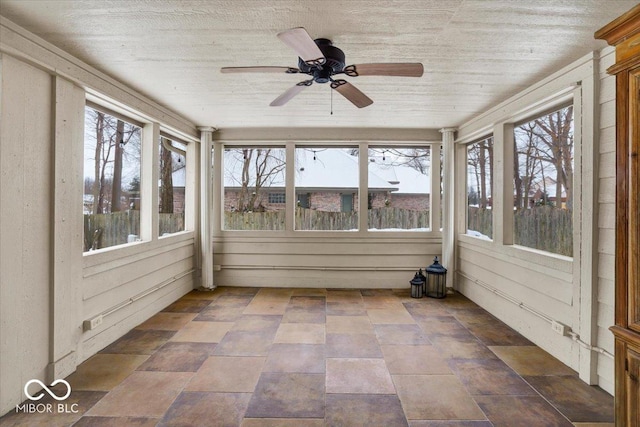 unfurnished sunroom featuring ceiling fan and plenty of natural light