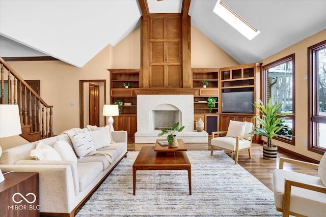 living room featuring high vaulted ceiling, hardwood / wood-style flooring, a skylight, and a fireplace