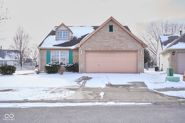 traditional-style home with a garage, central air condition unit, and brick siding