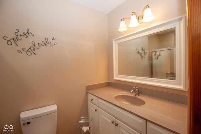 bathroom featuring a shower with door, toilet, and vanity