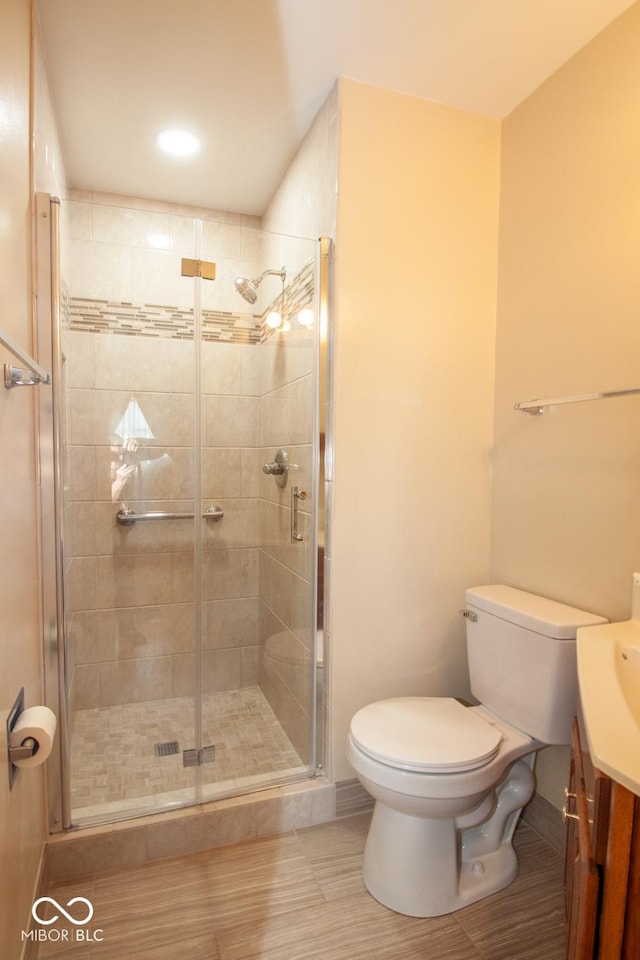 full bathroom with toilet, a stall shower, and vanity