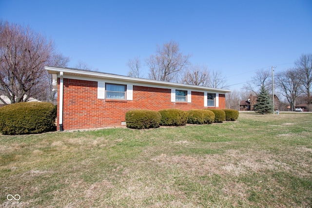 view of side of home featuring a lawn and brick siding