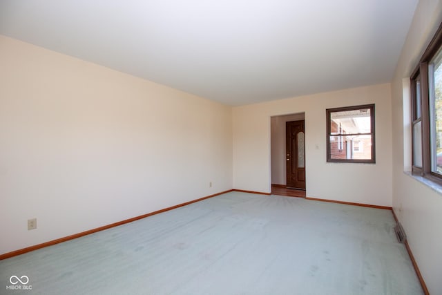 spare room with light colored carpet and baseboards