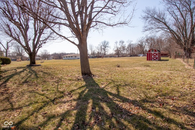 view of yard featuring an outdoor structure, a rural view, and a barn