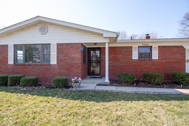 single story home featuring brick siding and a front lawn