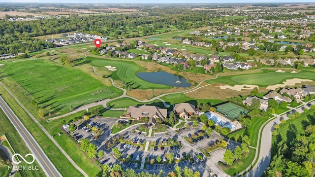 drone / aerial view with view of golf course and a water view