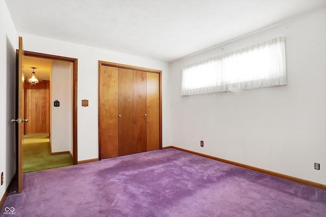 unfurnished bedroom featuring carpet floors, a closet, and baseboards