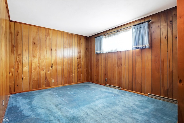 carpeted spare room with baseboards, wooden walls, and visible vents