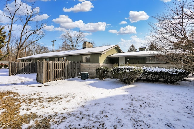 exterior space with central AC, a chimney, and fence