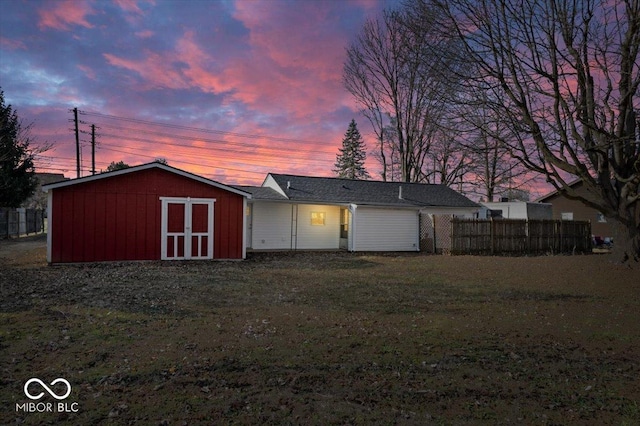 exterior space featuring an outbuilding, a storage shed, a yard, and fence