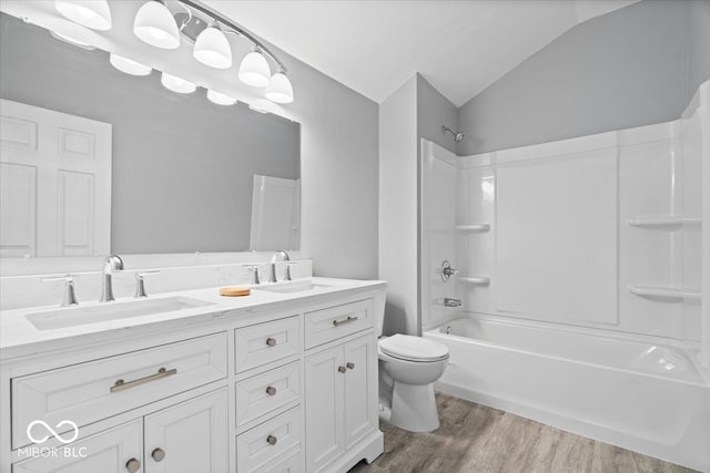 full bath with a sink, toilet, wood finished floors, and vaulted ceiling