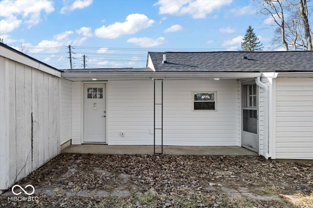 entrance to property with roof with shingles