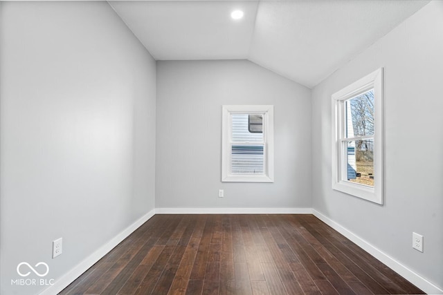 unfurnished room with dark wood-type flooring, baseboards, and vaulted ceiling