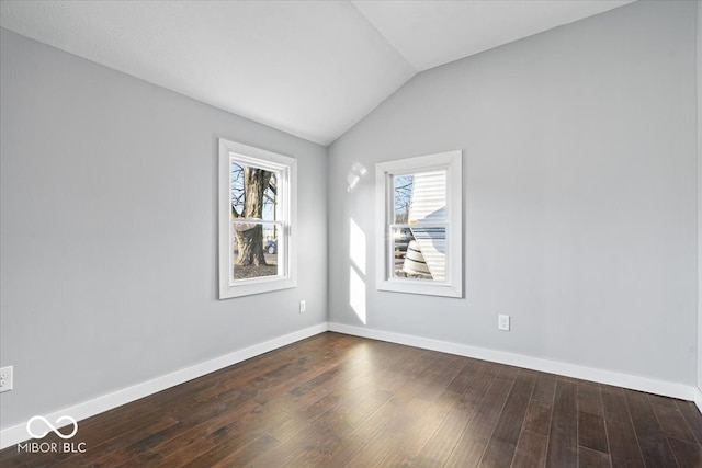 unfurnished room with dark wood-style floors, baseboards, and vaulted ceiling