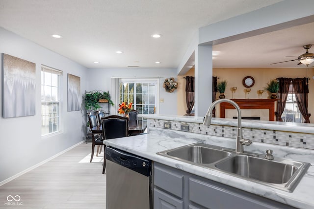 kitchen with a healthy amount of sunlight, dishwasher, a sink, and gray cabinetry