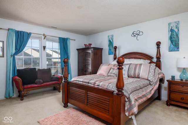 bedroom with a textured ceiling, carpet floors, and visible vents