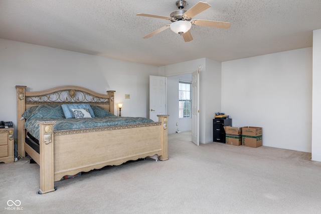 carpeted bedroom featuring a textured ceiling and a ceiling fan