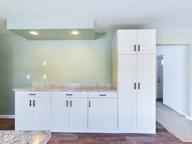 interior space with light stone counters, recessed lighting, dark wood-style flooring, and white cabinetry