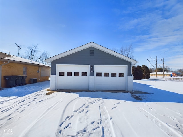 snow covered garage with a garage