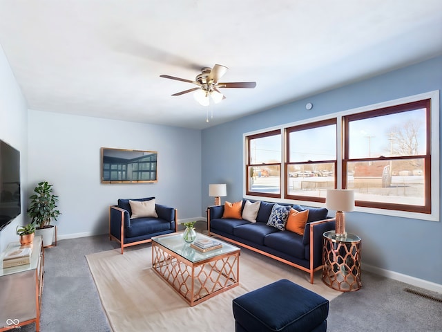 carpeted living area featuring ceiling fan, visible vents, and baseboards