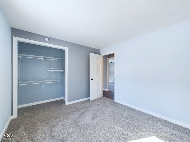 unfurnished bedroom featuring carpet floors, baseboards, and a closet