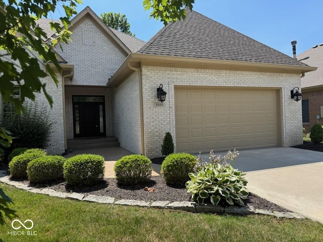 1655 Rosebud Ln, Greenwood, IN 46143 - view of front of property with driveway, brick siding, a shingled roof, and an attached garage