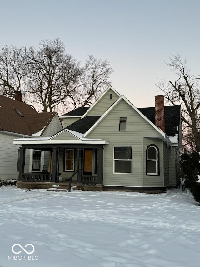 view of front of property featuring covered porch and a chimney