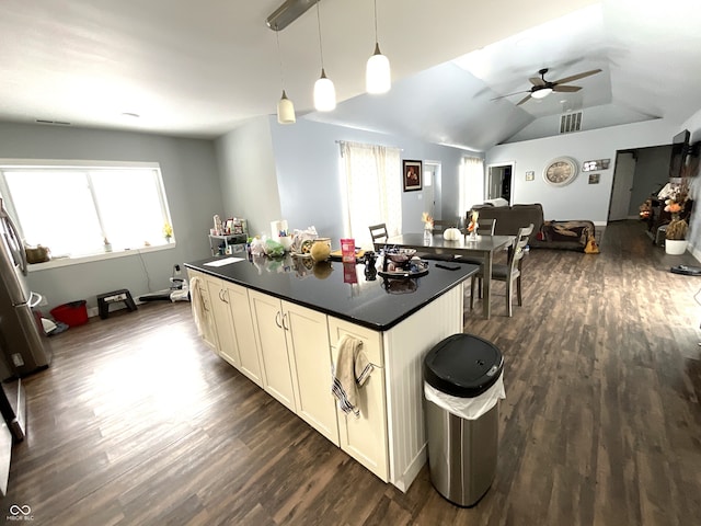 kitchen featuring dark countertops, dark wood-style floors, open floor plan, and decorative light fixtures