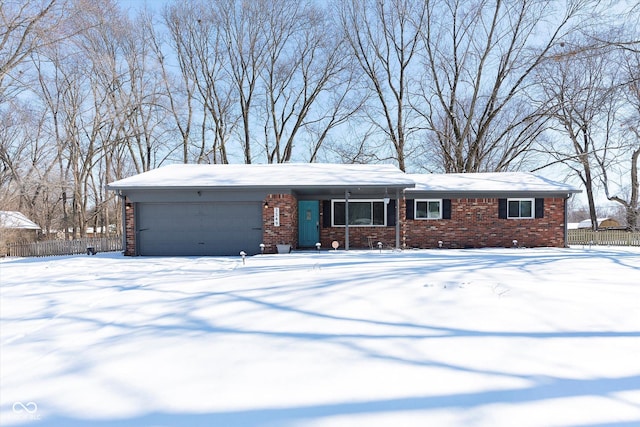 view of front of home with an attached garage, fence, and brick siding