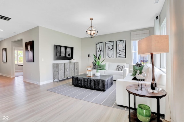2134 Boxwood Dr, Greenfield, IN 46140 - living room featuring light wood-style floors, baseboards, visible vents, and a notable chandelier