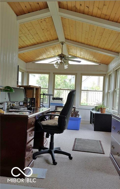 office area featuring vaulted ceiling with beams, light carpet, and wood ceiling