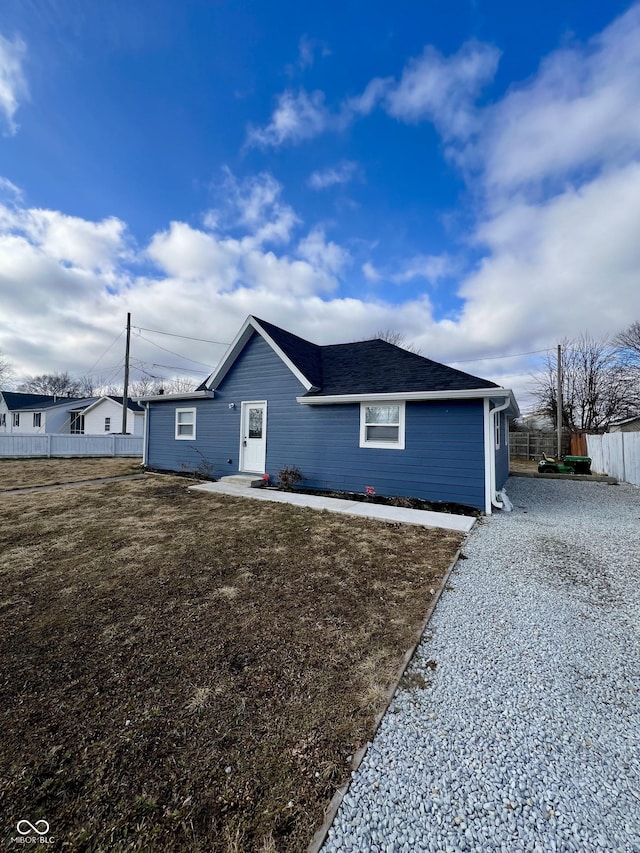 view of front of property with driveway, fence, and a front yard