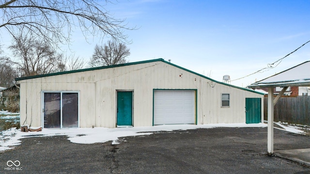 snow covered garage featuring a detached garage