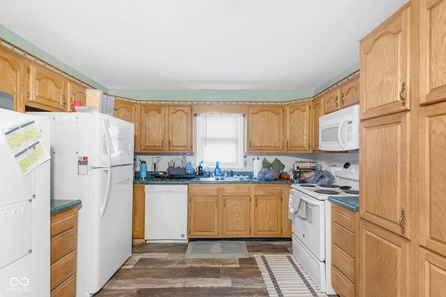 kitchen with a sink, dark wood-style flooring, dark countertops, and white appliances