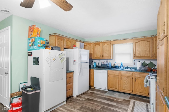 kitchen featuring visible vents, dark countertops, white appliances, and dark wood finished floors