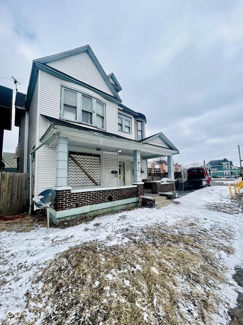 view of front of home featuring a porch and fence