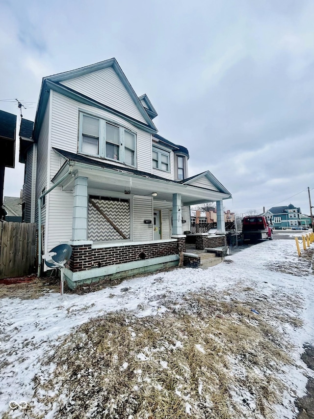 view of front of home featuring a porch and fence