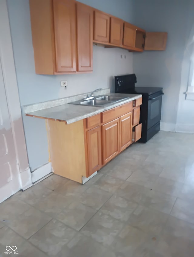 1808 E Washington St, Indianapolis, IN 46201 - kitchen featuring a sink, black / electric stove, baseboards, and light countertops