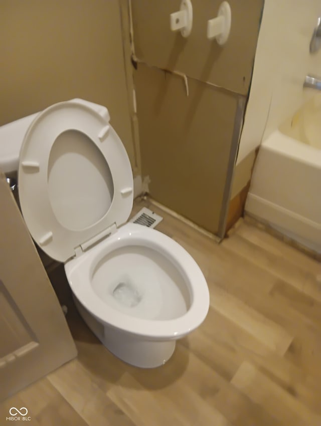 1808 E Washington St, Indianapolis, IN 46201 - bathroom with visible vents, wood finished floors, toilet, and a tub