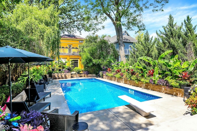 pool featuring a diving board and a patio