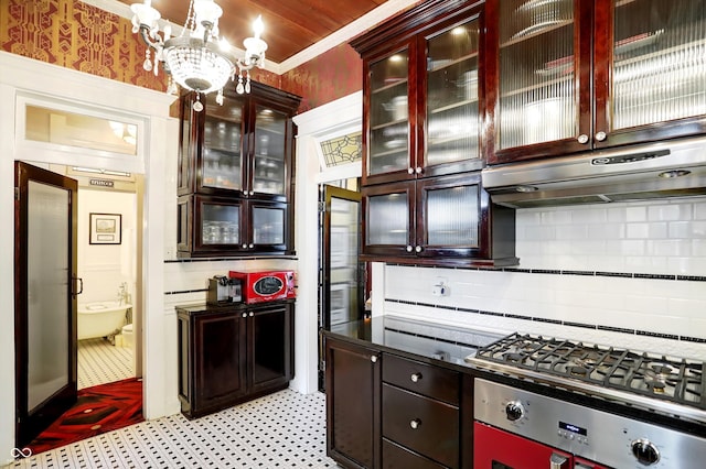 kitchen with wall oven, under cabinet range hood, reddish brown cabinets, tasteful backsplash, and stainless steel gas stovetop